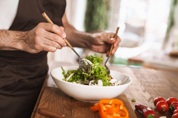 CLoseup portrait of a male hands preparing salad