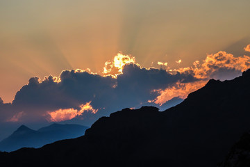 tramonto rosso dietro le nuvole e raggio di luce