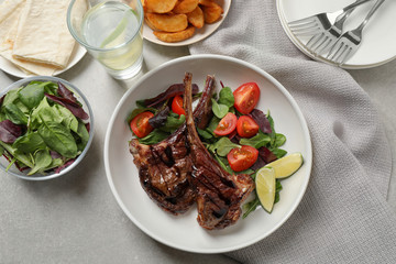 Delicious grilled ribs served on light grey table, flat lay