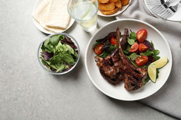 Delicious grilled ribs served on light grey table, flat lay