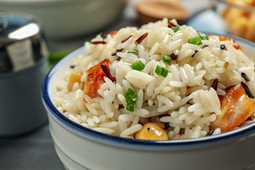 Delicious rice pilaf with chicken in bowl, closeup