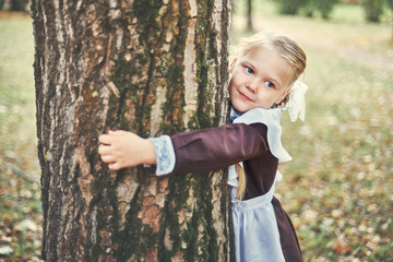 little girl hugged a tree. care concept.