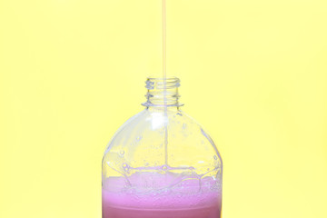 liquid soap is poured into a plastic bottle
