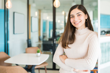 Hispanic Woman Smiling While Standing Confidently At Office