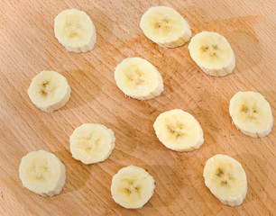 sliced banana slices on a wooden background. View from above.