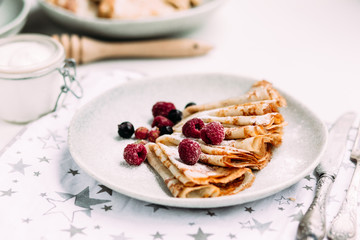 Pancakes with wild berries in a plate.Maslenitsa