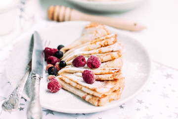 Pancakes with wild berries in a plate.Maslenitsa