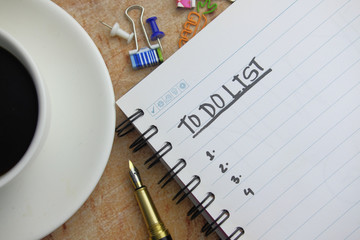 To do list written on notepad with tea on table