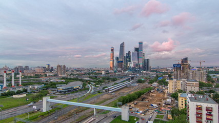 Naklejka na ściany i meble Business complex of skyscrapers Moscow city day to night timelapse. In the foreground the railway and automobile overpass.