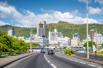 PORT LOUIS, MAURITIUS - APRIL 28, 2019: City traffic with buildings and beautiful landscape