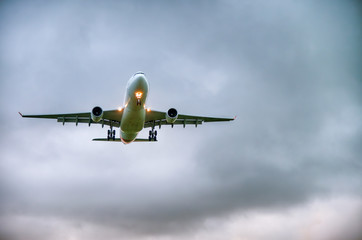Airplane landing against a cloudy day