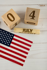 Obraz premium Independence day. Top view on USA flag and wooden cube calendar with 4 of July date