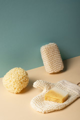 Obraz na płótnie Canvas Sponges, exfoliating glove with soap on beige and grey, zero waste concept