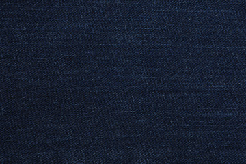Texture of dark blue jeans as background, closeup