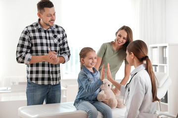 Parents and daughter visiting pediatrician. Doctor working with patient in hospital