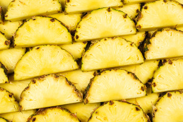 Pineapple juicy yellow slices background. Top view.