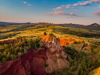 Beautiful landscape of the remains of an old sleeping volcano crater with red clay and vibrant colors, Racos, Brasov County, Transylvania, Romania