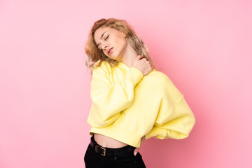 Fototapeta premium Young blonde woman wearing a sweatshirt isolated on pink background suffering from pain in shoulder for having made an effort