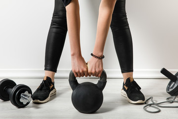 cropped view of athletic woman training with kettlebell at home with sports stuff