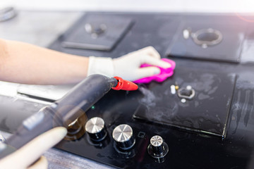 cleaning glass-ceramic gas stove with a steam cleaner.
