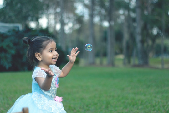 Little girl playing with bubbles