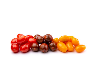yellow, red and brown cherry tomatoes on a white isolated background