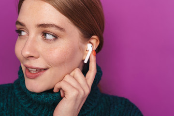 Photo of smiling caucasian woman using wireless earphone