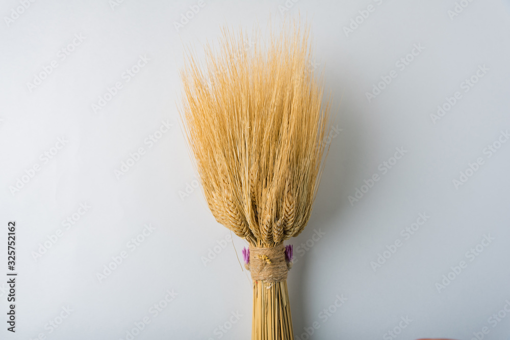 Wall mural a bouquet of yellow wheat on a white background