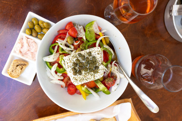 Traditional greek salad and carafe of wine in a tavern on the island in Greece.