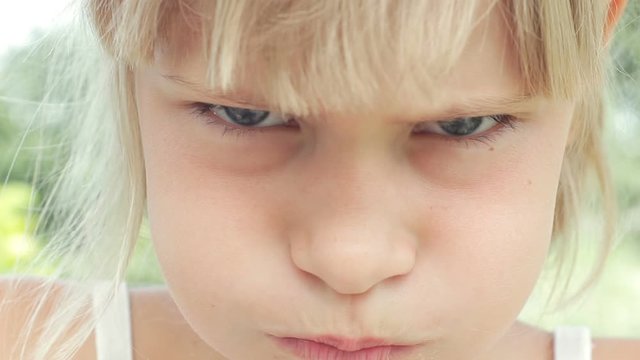 Sulky offended child girl pouting and grumpy close up portrait