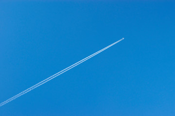 the plane flies in the sky leaving a trail