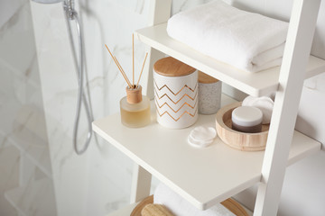 Shelving unit with different items in bathroom interior
