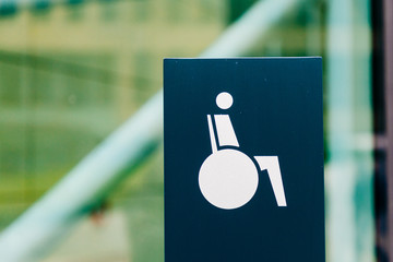 Sign with symbol wheelchair user shows the way to barrier-free access