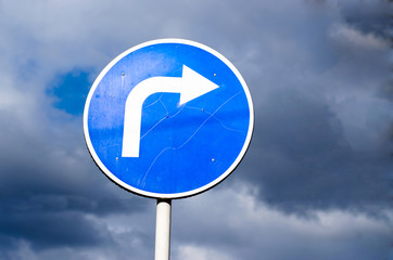 Turn right road sign on sky background with clouds