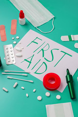 Creative layout of medicines for first aid, first aid kit for tourists, bandages, painkillers, plaster.cotton wool, cotton sticks, tampons on a turquoise background