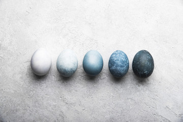 Fototapeta na wymiar Naturally dyed colorful Easter eggs on grey concrete background 
