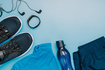 Creative layout of fitness clothing on a blue background, a symbol of a healthy lifestyle ,top view