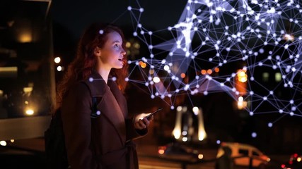 Redheaded girl uses hologram in night city. Young woman delighted to use augmented reality feature on her phone - Powered by Adobe
