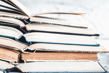 Opened books in a stack on a light home background. Education, hobbies