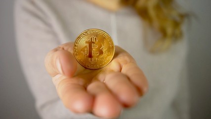 Cryptocurrency concept. Woman holding bitcoin in her hand. Digital currency in hand.
