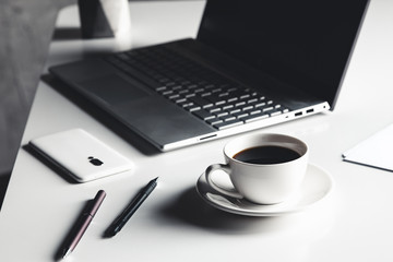 Business man using laptop computer with pen glasses and cup of hot coffee