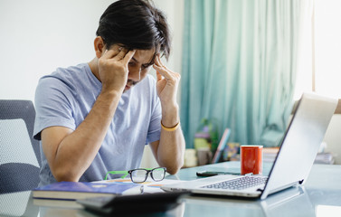 Asian businessmen having a headache in front of laptop ,Healthcare And Medicine concept, Office syndrome