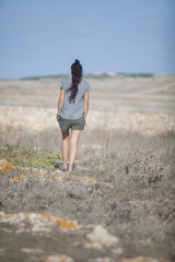 Mujer de espaldas andando por el campo