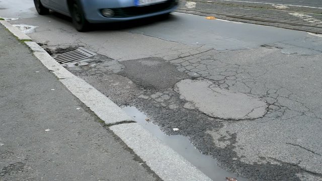 Pothole on the street - passing cars and trucks