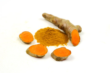 Turmeric powder and turmeric roots isolated on a white background are used as a tonic for the body and turmeric supplements or as an ingredient in food.