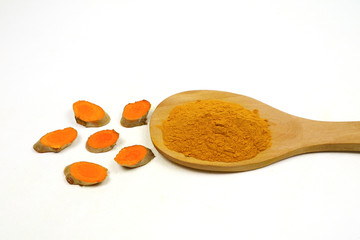 Turmeric powder in wooden spoons and turmeric roots isolated on a white background, used as a tonic for the body and turmeric supplements or as an ingredient in food.