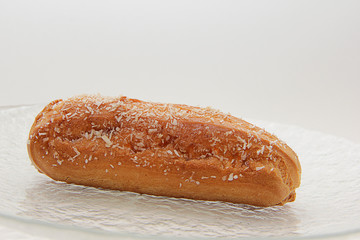 fresh Eclair on a transparent plate close-up