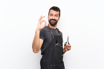 Barber man in an apron showing ok sign with fingers