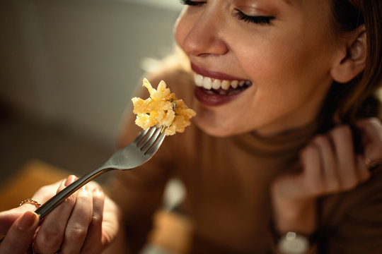 Close-up Of Happy Woman Enjoying While Eating Pasta.