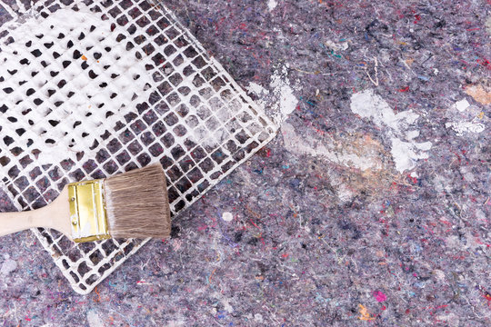 Painter fleece with spots of paint and wooden paintbrush